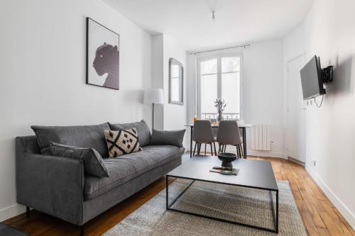 un salon avec un canapé et une table dans l'établissement 2 pieces refait neuf metro Jaures - paris 19 - 4P - FLAT-GUEST, à Paris