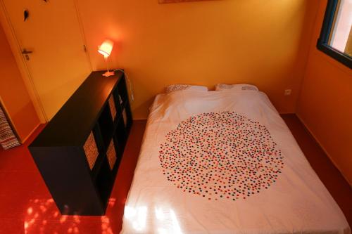 une chambre avec un lit avec un couvre-lit rouge et blanc dans l'établissement Studio Orange Oasis, à Salasc