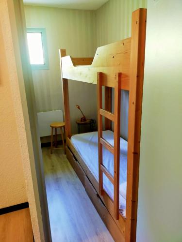 un lit superposé dans une petite pièce avec une échelle dans l'établissement OVGMontgenevre, à Montgenèvre