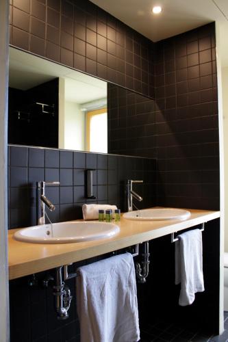 a bathroom with two sinks and a mirror at Balneario de la Albotea in Cervera del Río Alhama
