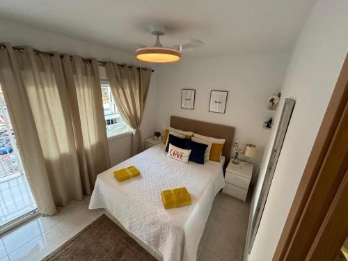 a bedroom with a bed with yellow pillows on it at Apartmento de 3 habitaciones con vistas al mar in Playa de Gandia