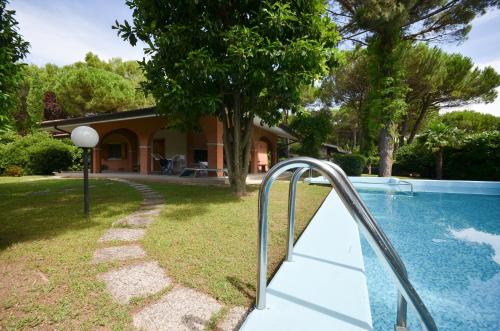 ein Haus mit Swimmingpool und ein Haus in der Unterkunft Villa Sabrina in Lignano Sabbiadoro