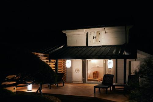a house with a deck at night with lights at KURA YARD in Fujikawaguchiko