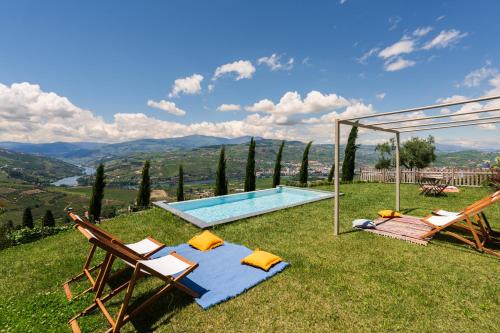 a villa with a swimming pool and two chairs at Host Wise - Casa dos Ciprestes - Pool & Vines Haven in Lamego