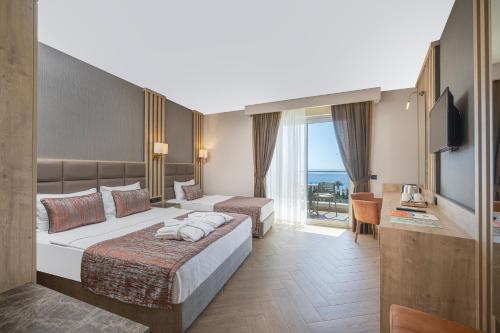 a hotel room with two beds and a balcony at My Home Resort Hotel- Ultra All Inclusive in Avsallar