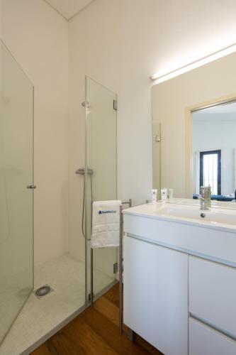 a white bathroom with a sink and a shower at Host Wise - Casa dos Ciprestes - Pool & Vines Haven in Lamego