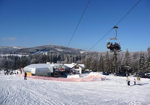 a group of people on a ski lift in the snow at Apartmán Ramzová Kometa in Ostružná