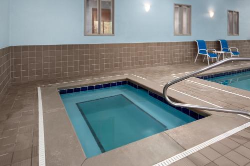 a swimming pool with a tile floor and blue tiles at Holiday Inn Express Hotel & Suites Dubois by IHG in DuBois