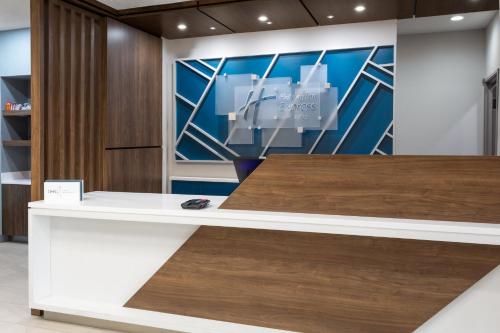 a reception desk in a lobby with a painting at Holiday Inn Express Hotel & Suites Dubois by IHG in DuBois