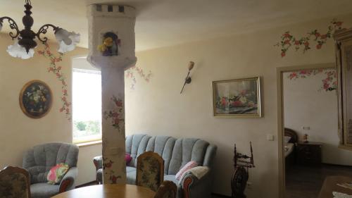 a living room with a table and blue chairs at Märchenpension Rotkäppchen und der Wolf in Großwaltersdorf