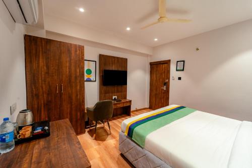 Una televisión o centro de entretenimiento en Treebo Premium Omni Residency