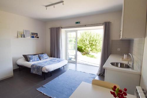 a room with a bed and a kitchen with a window at Casa nas Serras in Vila Nova de Poiares