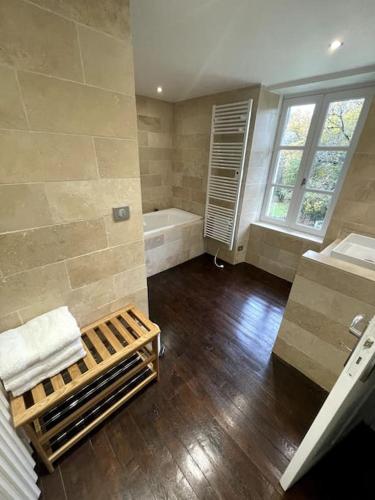une grande salle de bain avec une baignoire et un lavabo dans l'établissement Le manoir Lacalmontie, à Vitrac