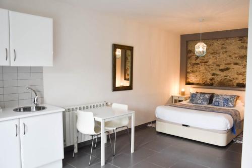 a bedroom with a bed and a table and a sink at Casa nas Serras in Vila Nova de Poiares