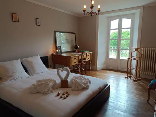 - une chambre avec un lit, un bureau et une fenêtre dans l'établissement Le manoir Lacalmontie, à Vitrac