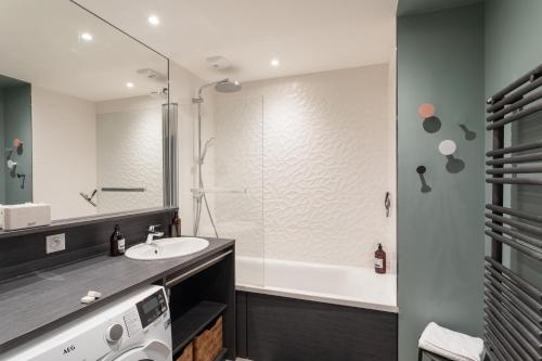 a bathroom with a sink and a shower at Les Sternes - Appt proche de la plage in Saint Malo