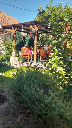 a wooden pergola with a table and chairs in a yard at VÉNUS in Dessenheim