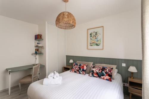 a bedroom with a bed with two towels on it at Les Sternes - Appt proche de la plage in Saint Malo