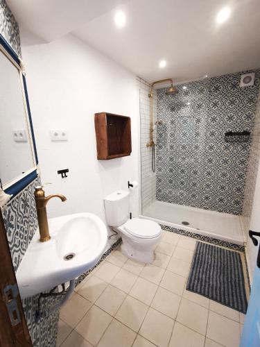a bathroom with a toilet and a sink and a shower at O Ninho in Cepos