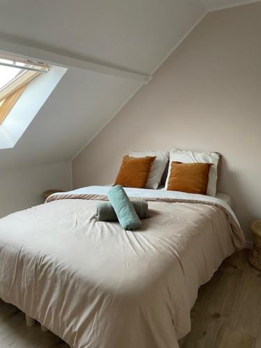 une chambre avec un grand lit blanc avec des oreillers dans l'établissement La jolie citadine, à Tourcoing