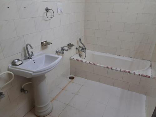 a bathroom with a sink and a bath tub at RAHUL Homestay in Sainj