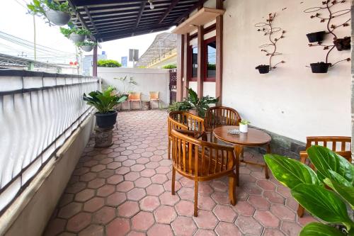 a patio with a table and chairs and plants at Wisma Falira Serang Syariah Mitra RedDoorz in Banjar