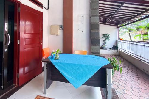 a table with a blue table cloth on a balcony at Wisma Falira Serang Syariah Mitra RedDoorz in Banjar