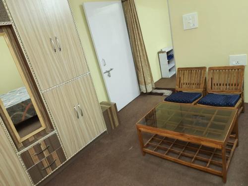 a room with two chairs and a table and a mirror at RAHUL Homestay in Sainj