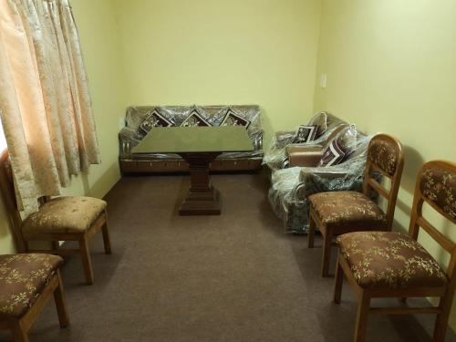 a living room with a couch and a table and chairs at RAHUL Homestay in Sainj