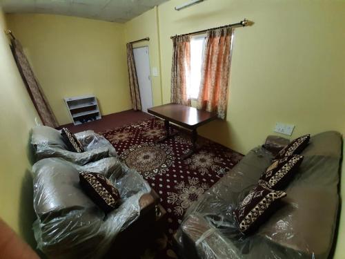 a living room with a couch and a table at RAHUL Homestay in Sainj