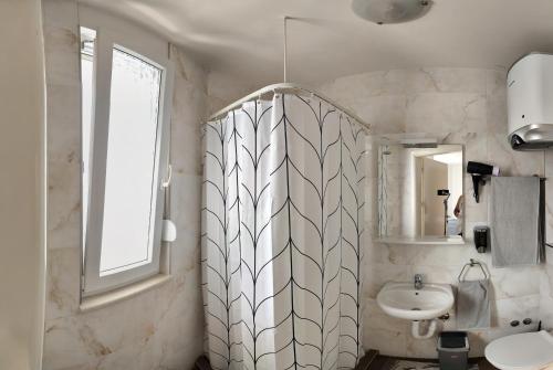 a bathroom with a sink and a mirror at Apartments Mariot in Split