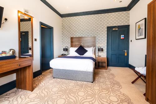 a hotel room with a bed and a desk and a desk at The Coach House Suffolk in Lowestoft