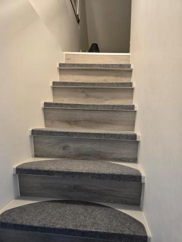 a stairway with wooden steps and a rug at Hiška 111 s kopalnimi kartami in Brežice