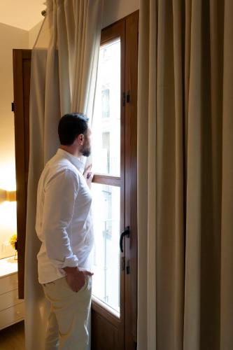 a man is standing in front of a window at Vivienda Turística CASA QUEVEDO in Úbeda
