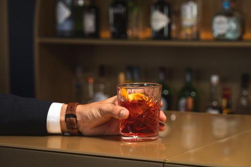 a person holding a drink in a glass at Hotel do Chiado in Lisbon