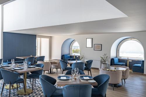 a restaurant with tables and chairs and windows at Hotel do Chiado in Lisbon