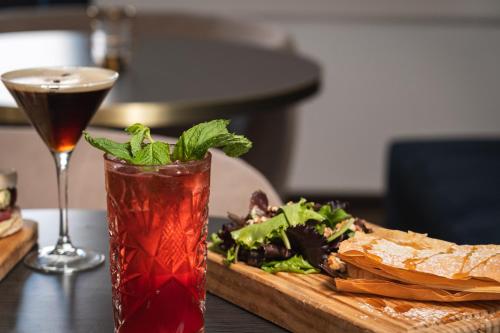 a wooden table with a drink and a plate of food at Hotel do Chiado in Lisbon