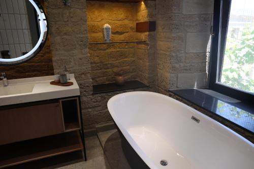 a bathroom with a tub and a sink and a mirror at Kilim Boutique Hotel in Baku