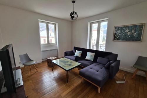 un salon avec un canapé et une table dans l'établissement Apt or chalet near the slopes Briançon, à Briançon