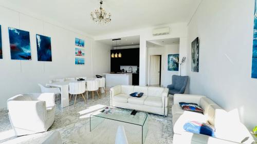 Il comprend un salon doté d'un mobilier blanc et une salle à manger. dans l'établissement Spacious 3 BR flat Nice center - magnificent view, à Nice