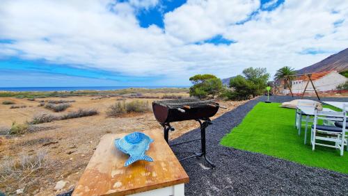 a grill and a table with a blue hat on it at Casa da Ponta by Casas dos Lebre in Porto Santo