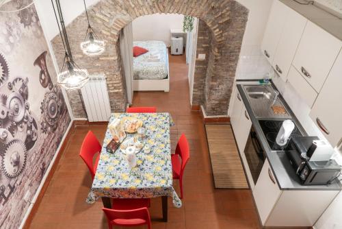 una cucina e una sala da pranzo con tavolo e sedie rosse di Casa De' Medici in via Giulia a Roma