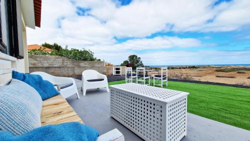 a patio with a table and chairs and a view of the ocean at Casa da Ponta by Casas dos Lebre in Porto Santo