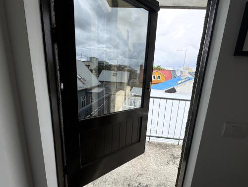 a door with a view of a city from a balcony at Day Dream L23 Guesthouse in Reykjavík