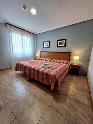 a bedroom with a large bed with two lamps at Hostal Europa in San Roque del Acebal
