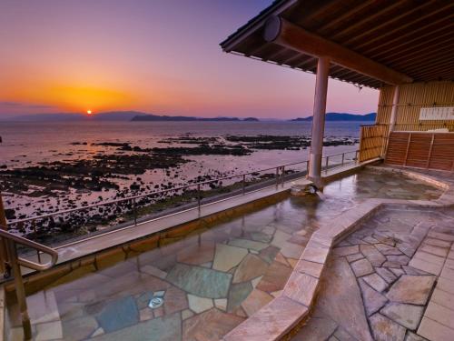 a view of the beach at sunset from a house at Wakayama Kada Onsen Kada Kaigetsu (ex. Azumaya Seaside Hotel) in Wakayama