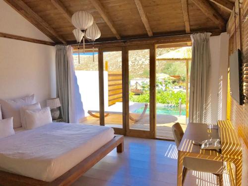 a bedroom with a bed and a table and a chair at Caesars Gardens Hotel & Spa - Adults Only in Líndos