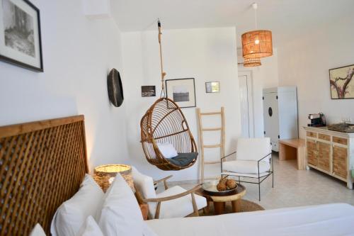 a living room with a couch and a hanging chair at Caesars Gardens Hotel & Spa - Adults Only in Líndos