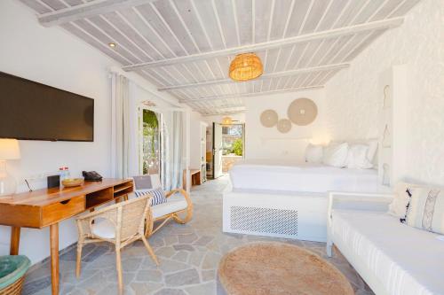 a bedroom with a bed and a desk and a couch at Caesars Gardens Hotel & Spa - Adults Only in Líndos