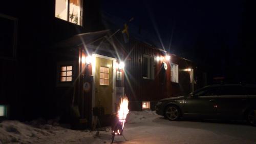 a person with a fire in front of a house at night at Storliens Fjällgård in Storlien